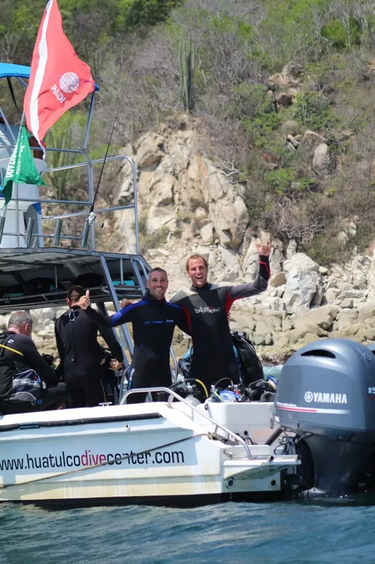 Plongée : des personnes souriantes sur un bateau en mer, drapeau PADI