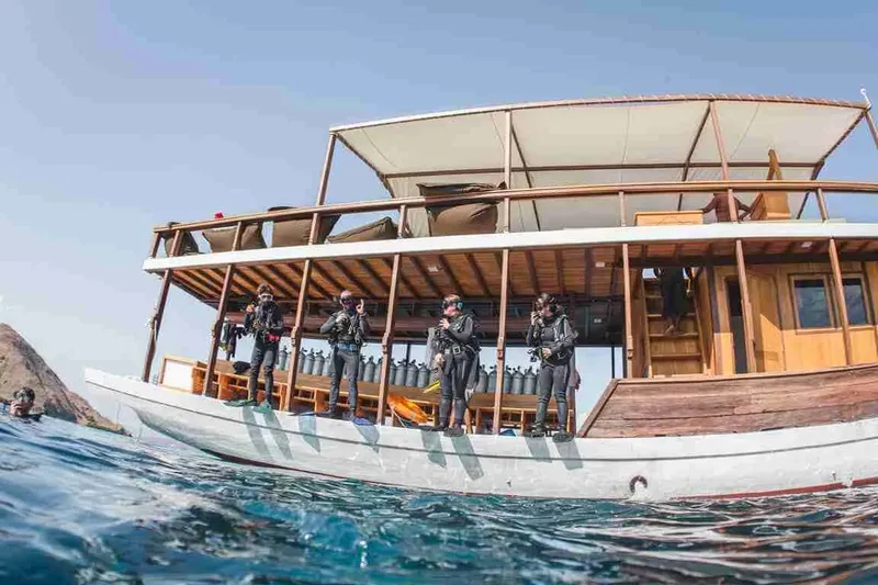 Plongeurs équipés se préparent à plonger depuis un bateau traditionnel