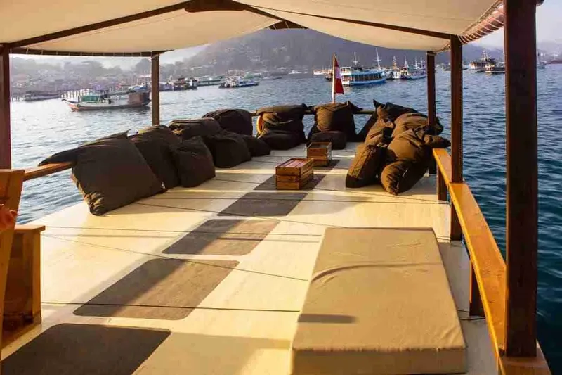 Terrasse de bateau avec coussins et vue sur la mer et bateaux