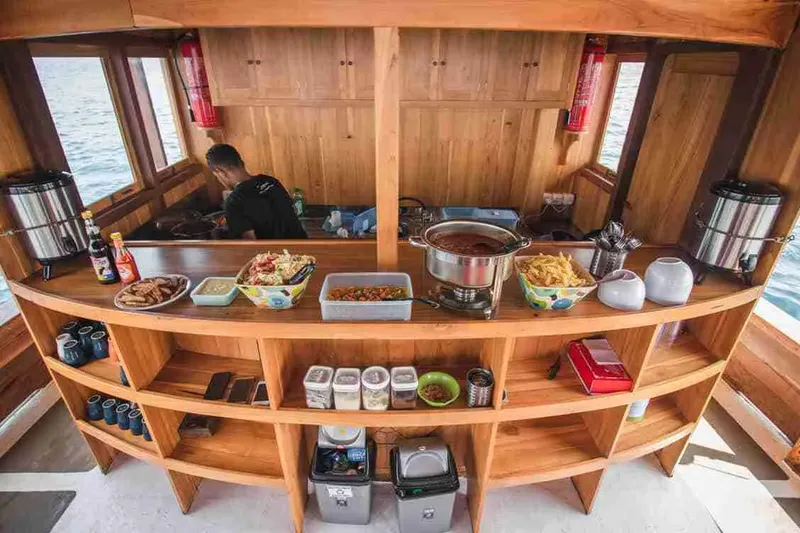 Intérieur d'un bateau de plongée avec une personne préparant des repas