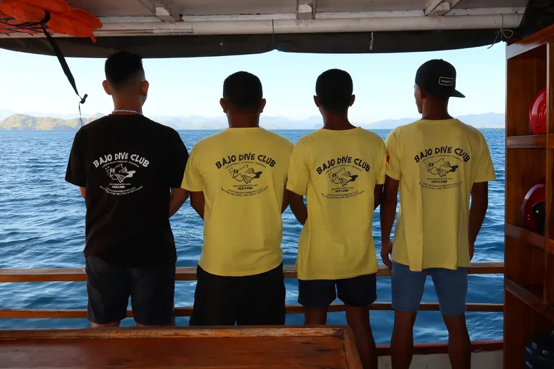 Quatre personnes regardent l'horizon depuis un bateau en mer