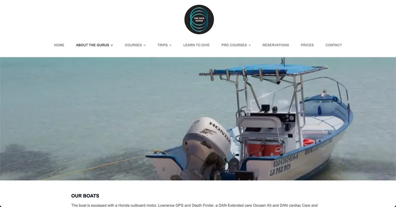 Bateau de plongée bleu et blanc amarré dans une eau turquoise claire