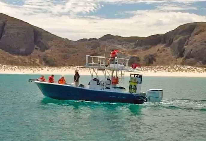 Bateau de plongée en mer avec des passagers et un paysage côtier