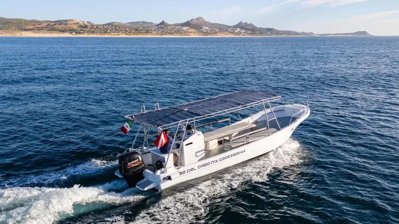 Bateau de plongée blanc naviguant sur une mer bleue claire