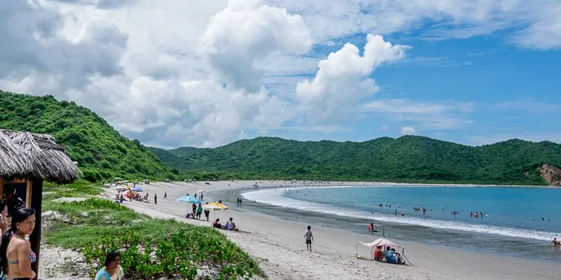 Plage de sable avec des personnes se baignant et se relaxant