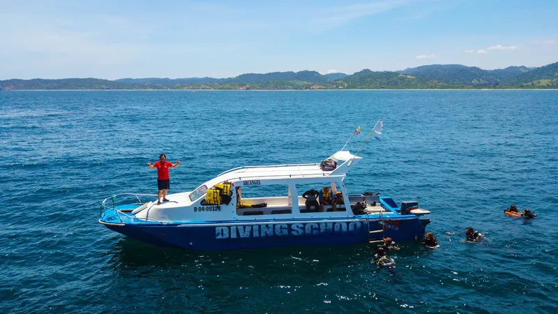 Bateau de plongée bleu et blanc avec des plongeurs en mer