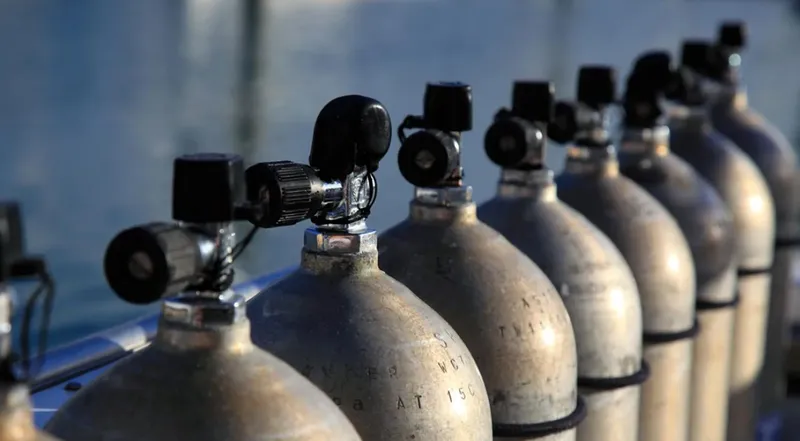 Rangée de bouteilles de plongée en aluminium avec détendeurs noirs