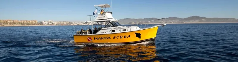 Bateau de plongée jaune en mer avec des passagers à bord
