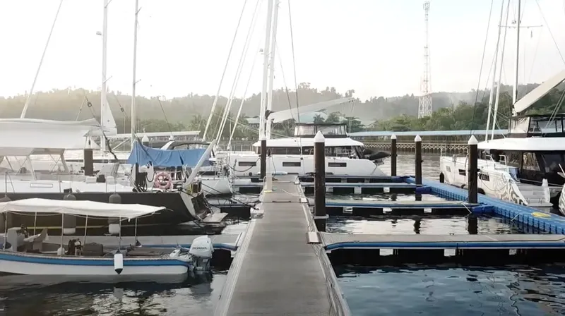 Plusieurs bateaux amarrés à un ponton dans une marina ensoleillée