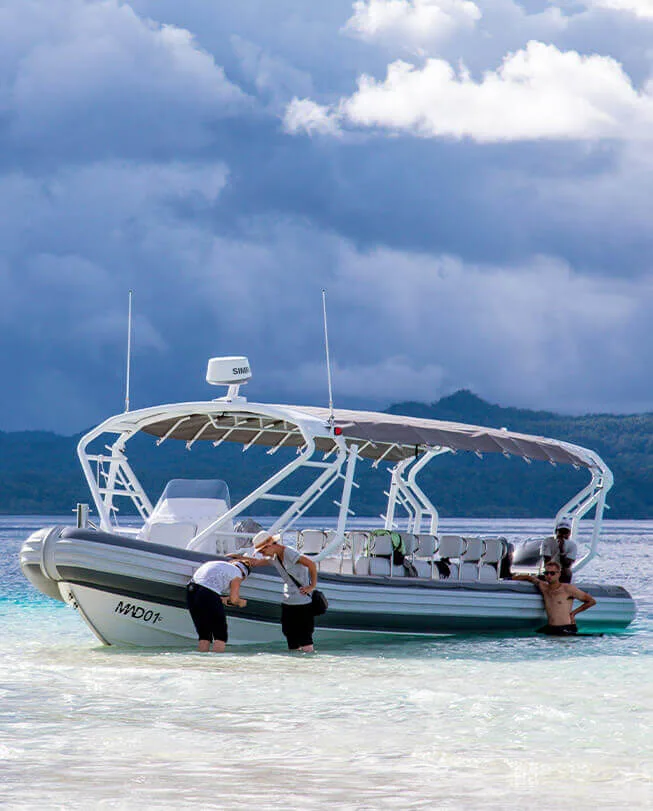 Plongée : des personnes montent à bord d'un bateau semi-rigide sur une plage