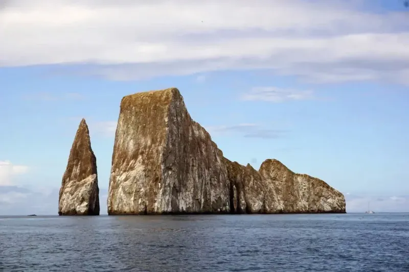 Rochers volcaniques émergeant de la mer sous un ciel nuageux