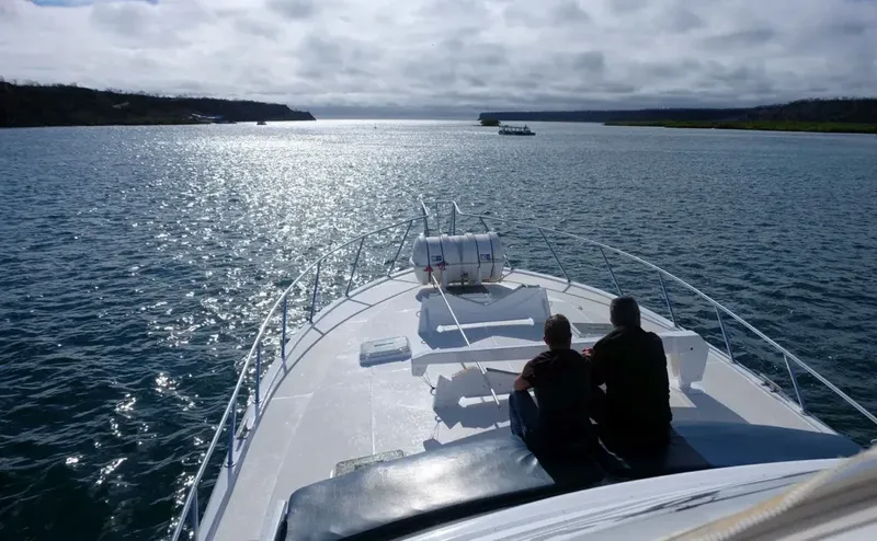 Deux personnes assises sur un bateau naviguant sur une mer scintillante