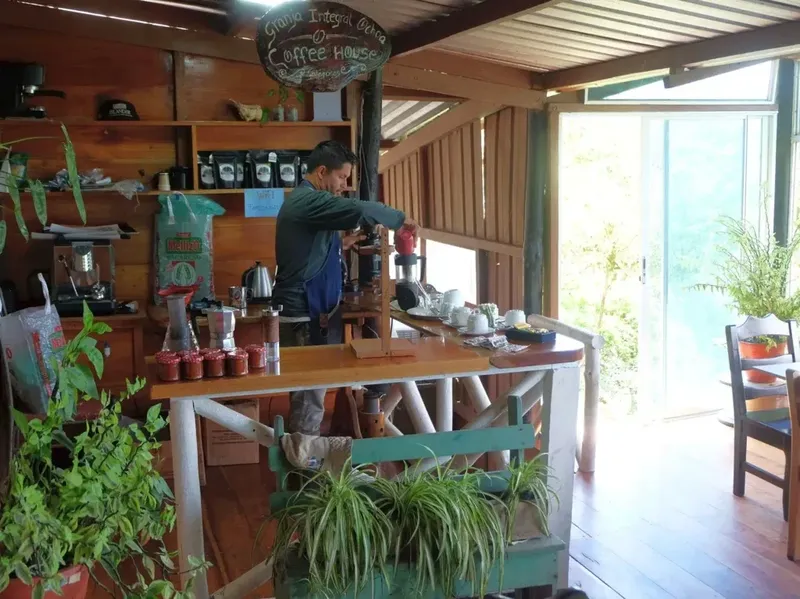 Un homme prépare du café derrière un comptoir en bois clair