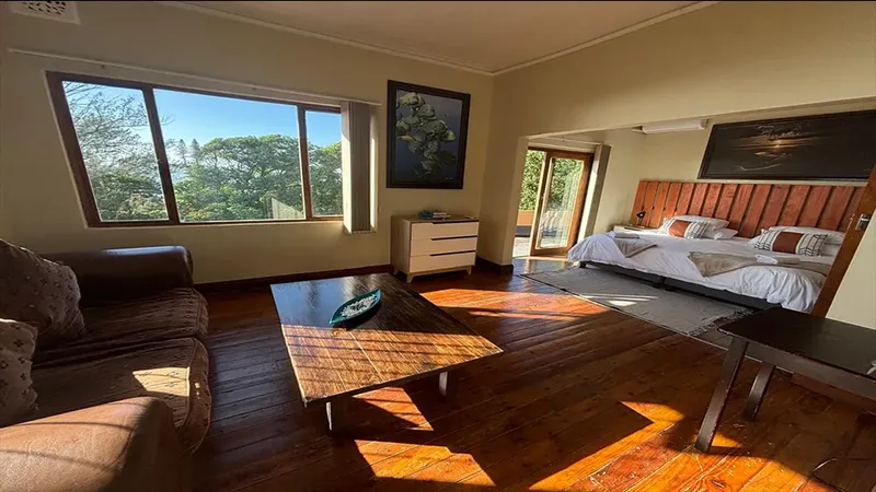 Chambre spacieuse avec salon, vue sur la végétation luxuriante et décoration bois