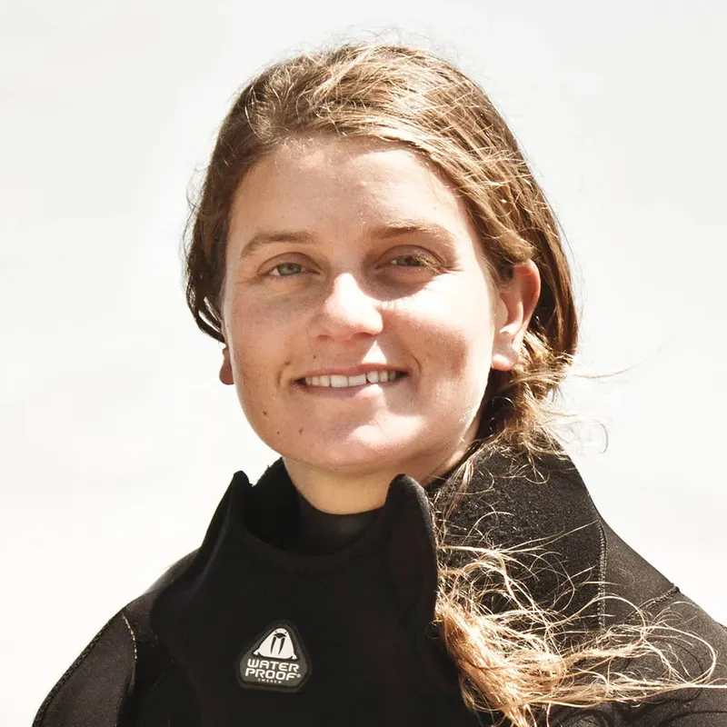 Portrait d'une jeune femme souriante portant une combinaison de plongée