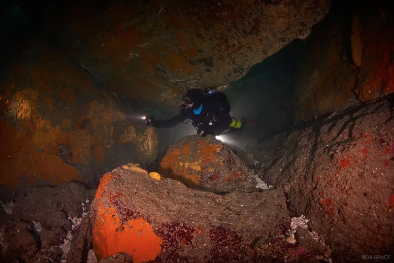 Plongeur explorant une grotte sous-marine éclairée par des lampes