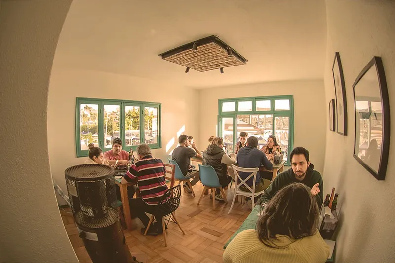 Groupe de personnes assises autour de tables dans une pièce lumineuse