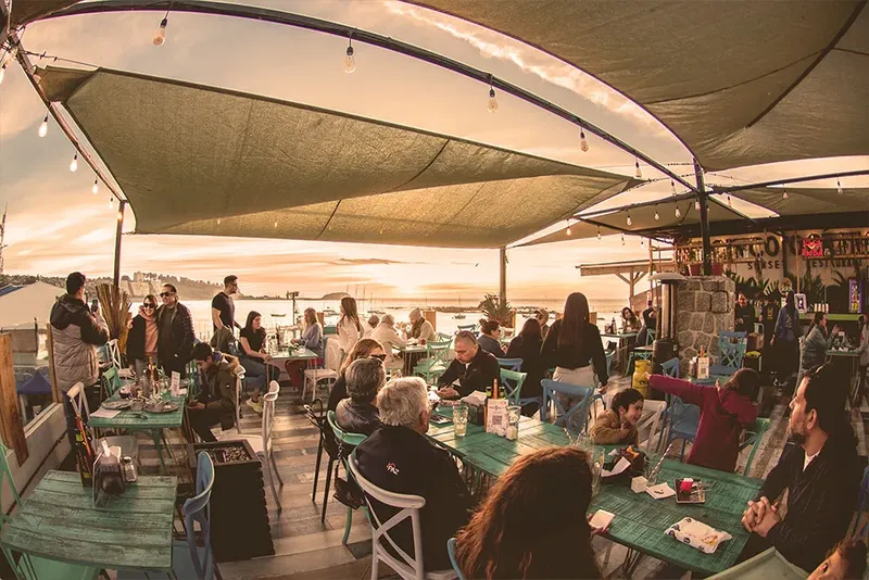 Terrasse d'un restaurant avec des clients, vue sur la mer et le ciel