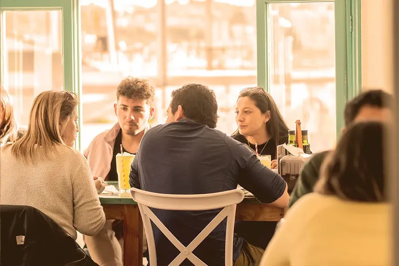Groupe de personnes assises autour d'une table dans un intérieur lumineux