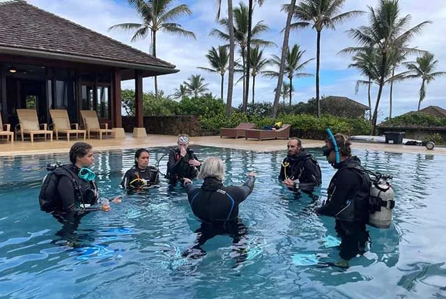 Groupe de plongeurs en formation dans une piscine avec instructeur