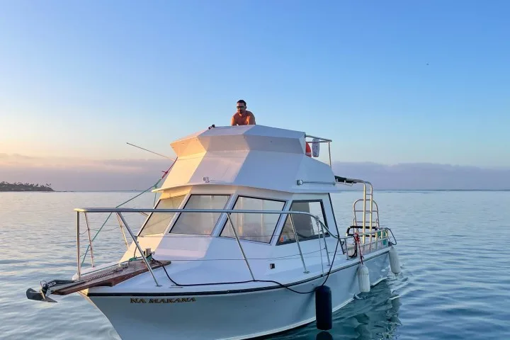 Homme sur le toit d'un bateau de plongée en mer calme