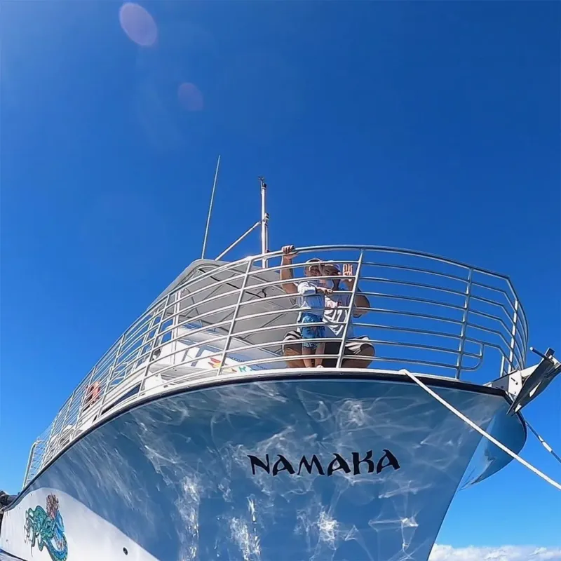 Vue plongeante d'un bateau avec des personnes à bord sous le soleil
