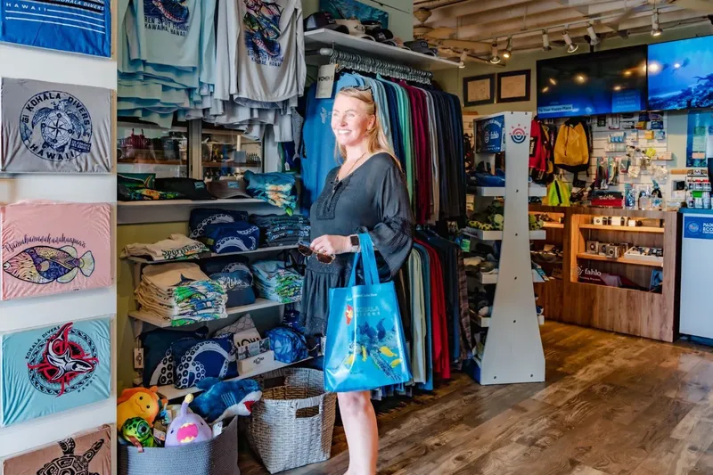 Femme souriante dans une boutique de plongée avec des articles à vendre