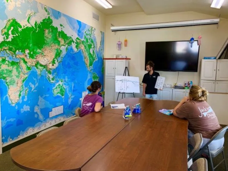 Cours de plongée en salle avec une carte du monde en fond