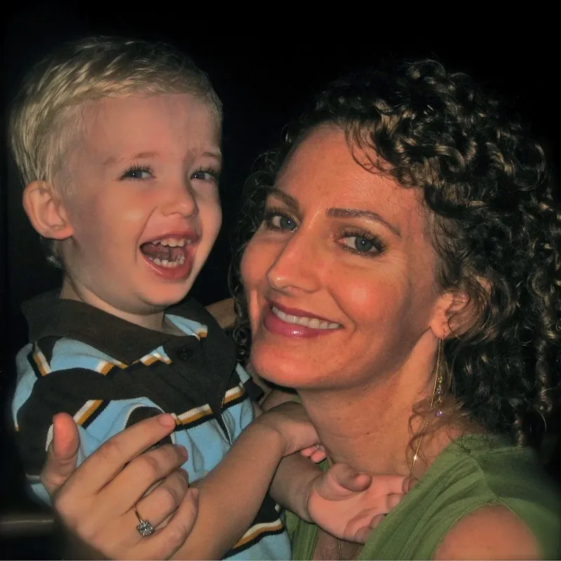 Femme souriante tenant un jeune enfant qui rit joyeusement