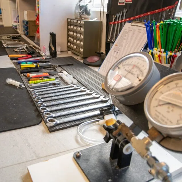 Atelier de maintenance avec outils, manomètres et pièces métalliques