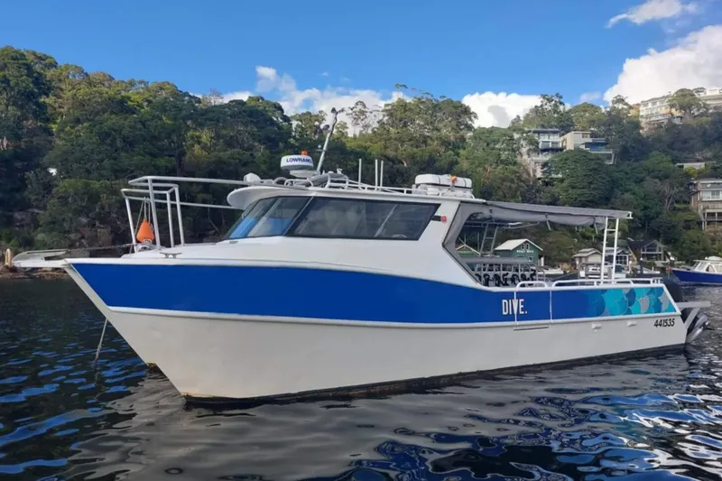 Bateau de plongée bleu et blanc naviguant sur une eau calme