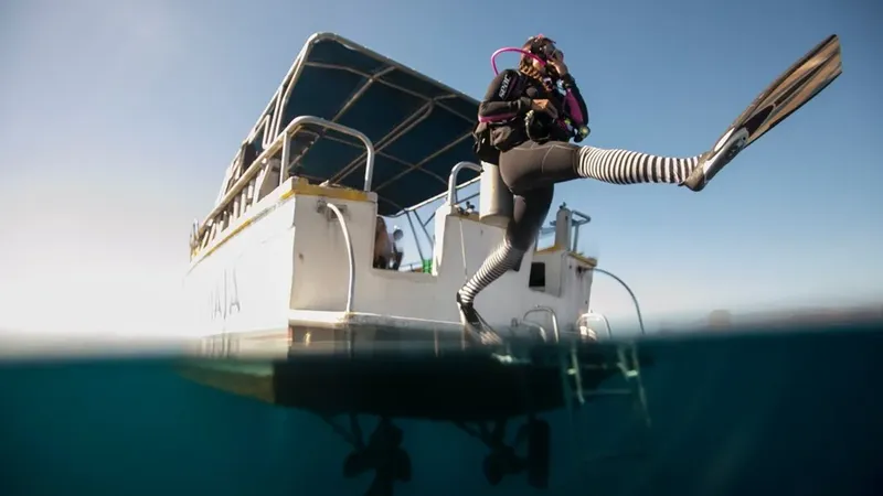 Plongeur s'apprête à entrer dans l'eau depuis un bateau de plongée