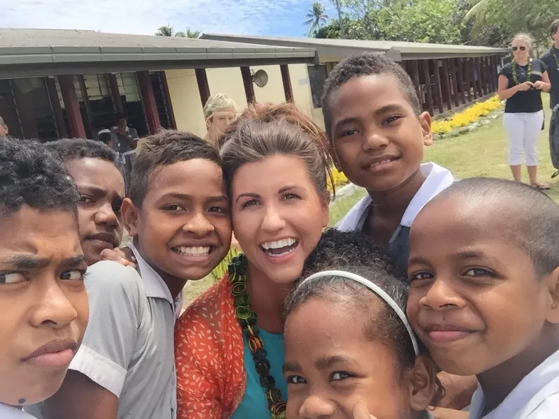 Groupe de personnes souriantes posant pour un selfie en extérieur