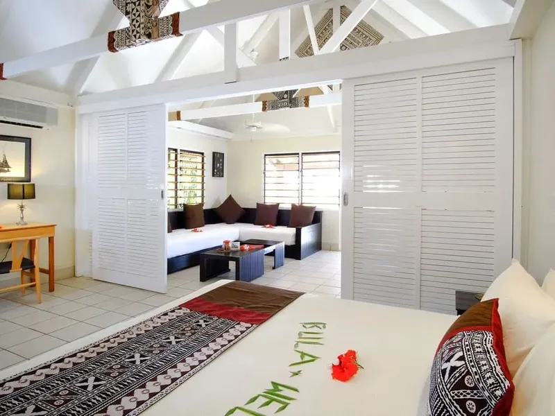 Intérieur d'une chambre d'hôtel lumineuse avec décoration tropicale et mobilier blanc
