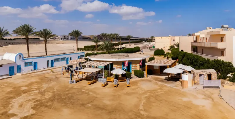 Centre de plongée avec matériel, parasols et bâtiments au bord de la mer