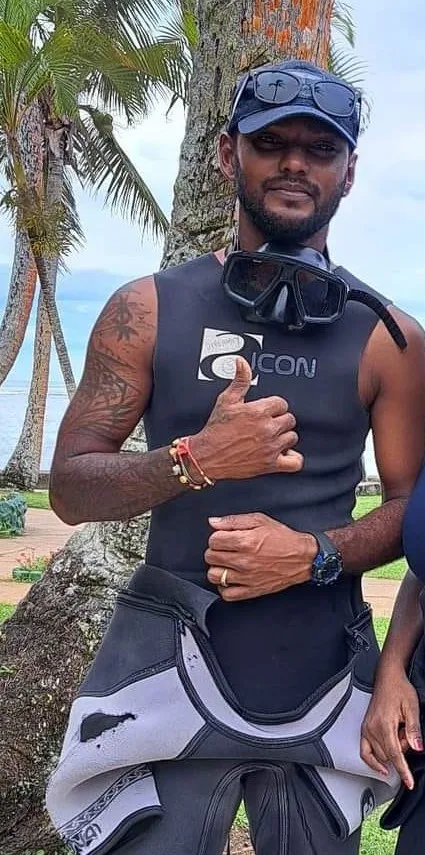 Plongeur souriant avec masque et combinaison, pouce levé, en extérieur
