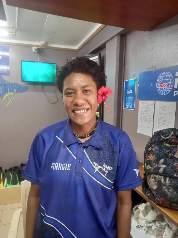 Femme souriante portant un polo avec un logo de centre de plongée