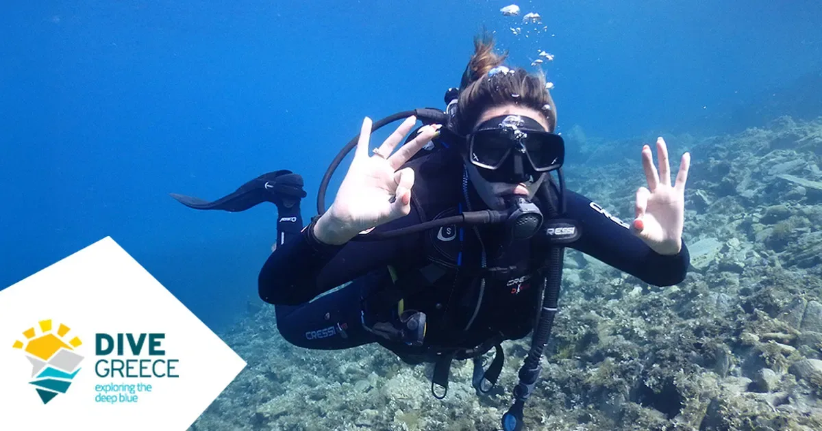 Plongeuse souriante avec signe de la main sous l'eau en Grèce