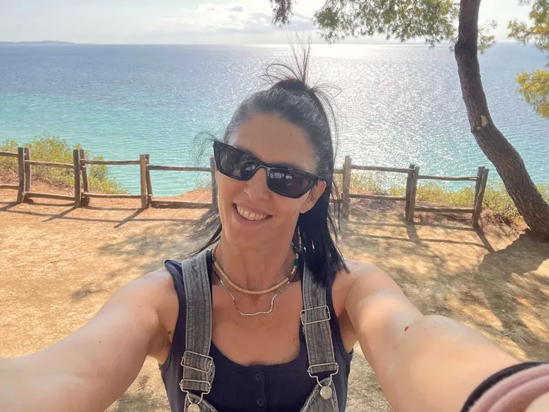 Femme souriante en selfie avec vue sur la mer et le ciel
