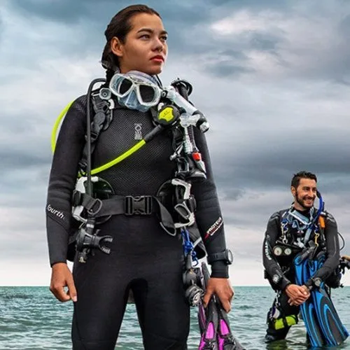 Deux plongeurs équipés, combinaison, détendeur, face à la mer