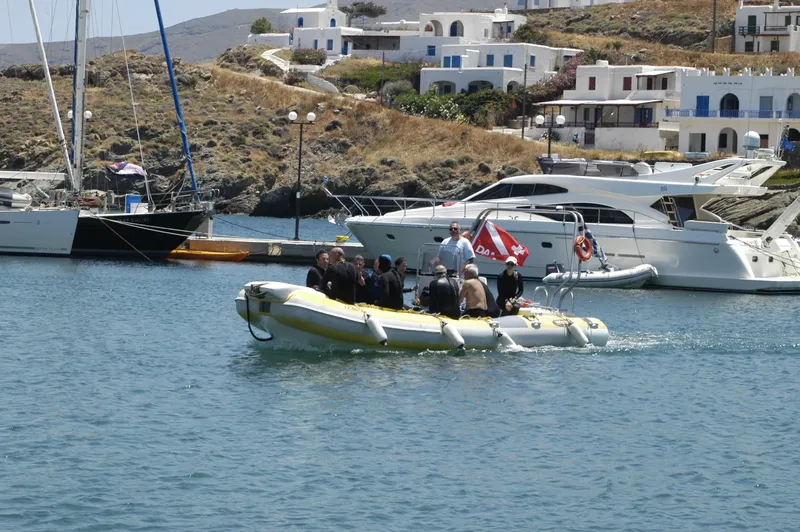 Groupe de plongeurs à bord d'un bateau semi-rigide dans un port
