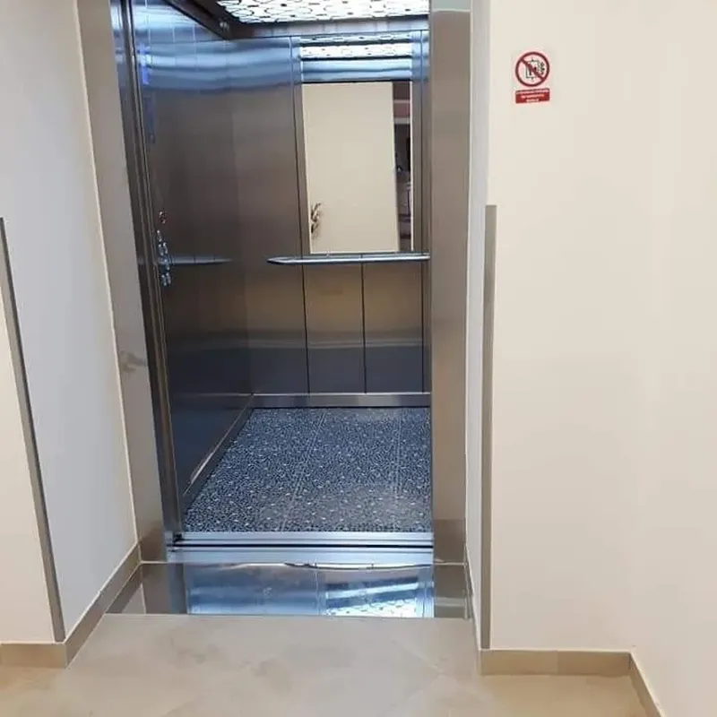 Ascenseur en inox ouvert sur un intérieur clair et moderne