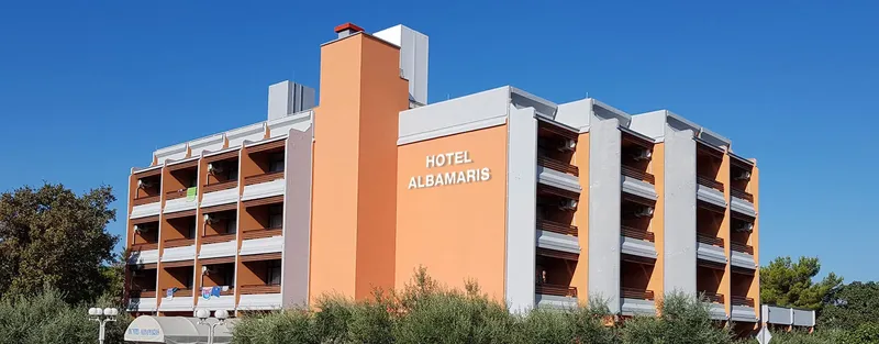Vue d'un bâtiment orange avec le nom Hotel Albamaris inscrit