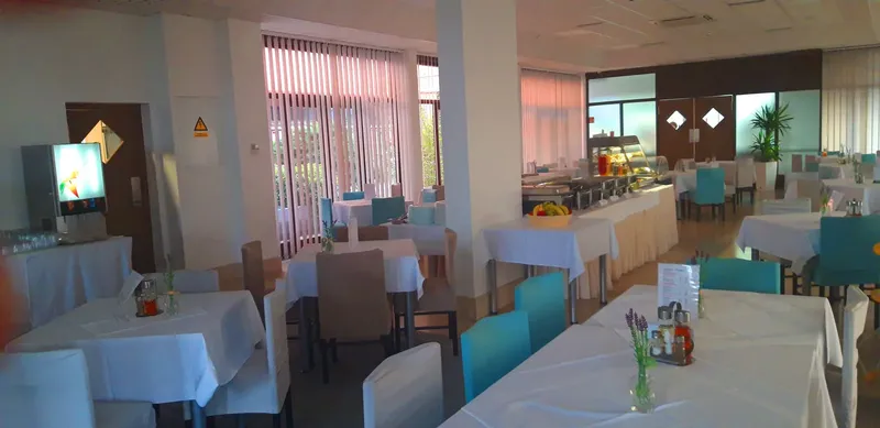 Salle de restaurant lumineuse avec tables nappées et décoration florale