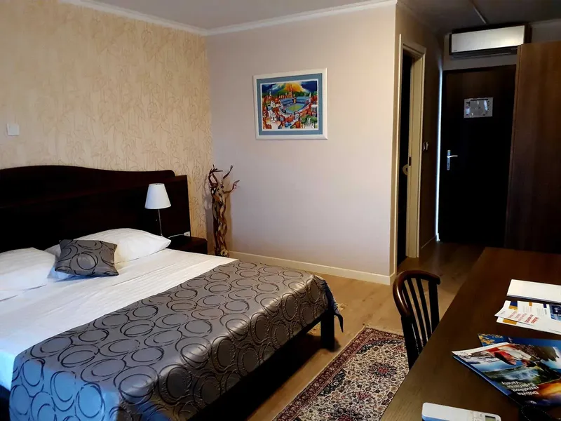 Chambre d'hôtel avec un lit double, une table de chevet et un bureau