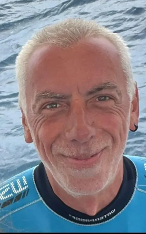 Portrait d'un homme souriant avec une combinaison de plongée bleue