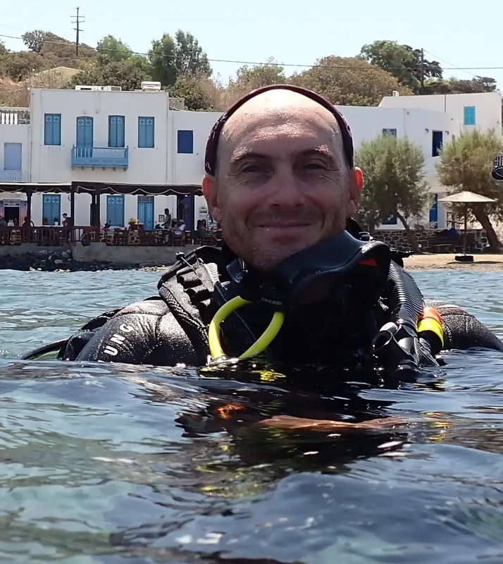 Plongeur souriant émerge de l'eau avec son équipement complet