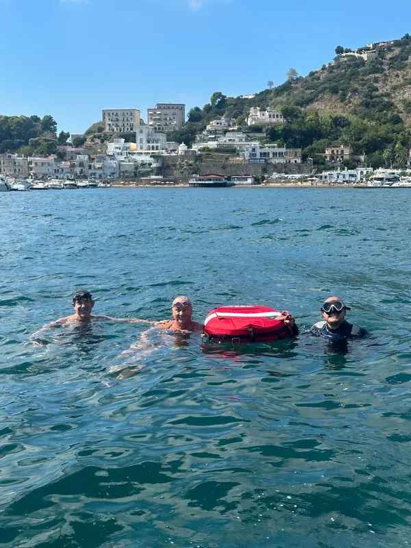 Trois personnes en maillot de bain flottent dans une eau turquoise