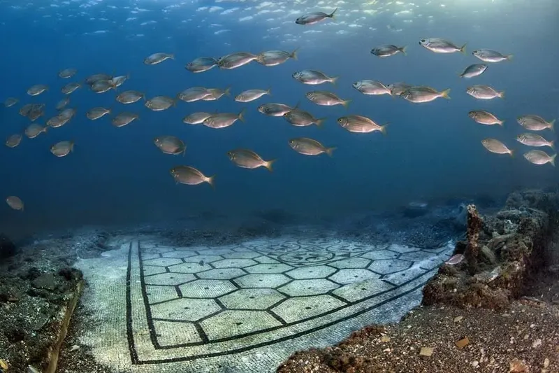 Banc de poissons au-dessus de vestiges antiques sous-marins clairs