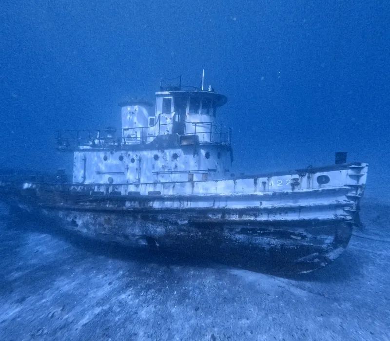 Epave de bateau de pêche reposant sur le fond marin sablonneux